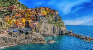 Vivid view of Manarola's colorful houses perched on cliffs, overlooking the blue sea.